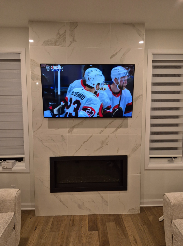 TV mounted above a marble fireplace in Ottawa home